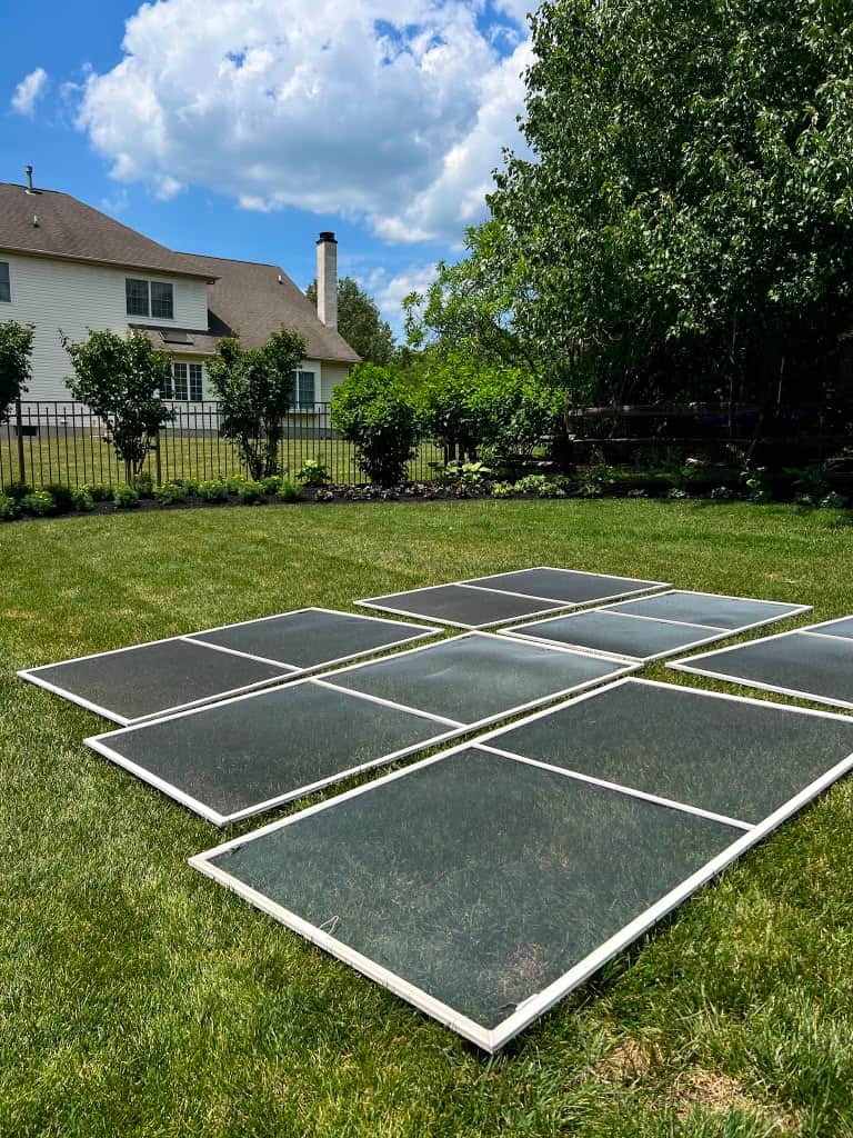 Window screens removed and laid out on the lawn for washing at a Bucks County property