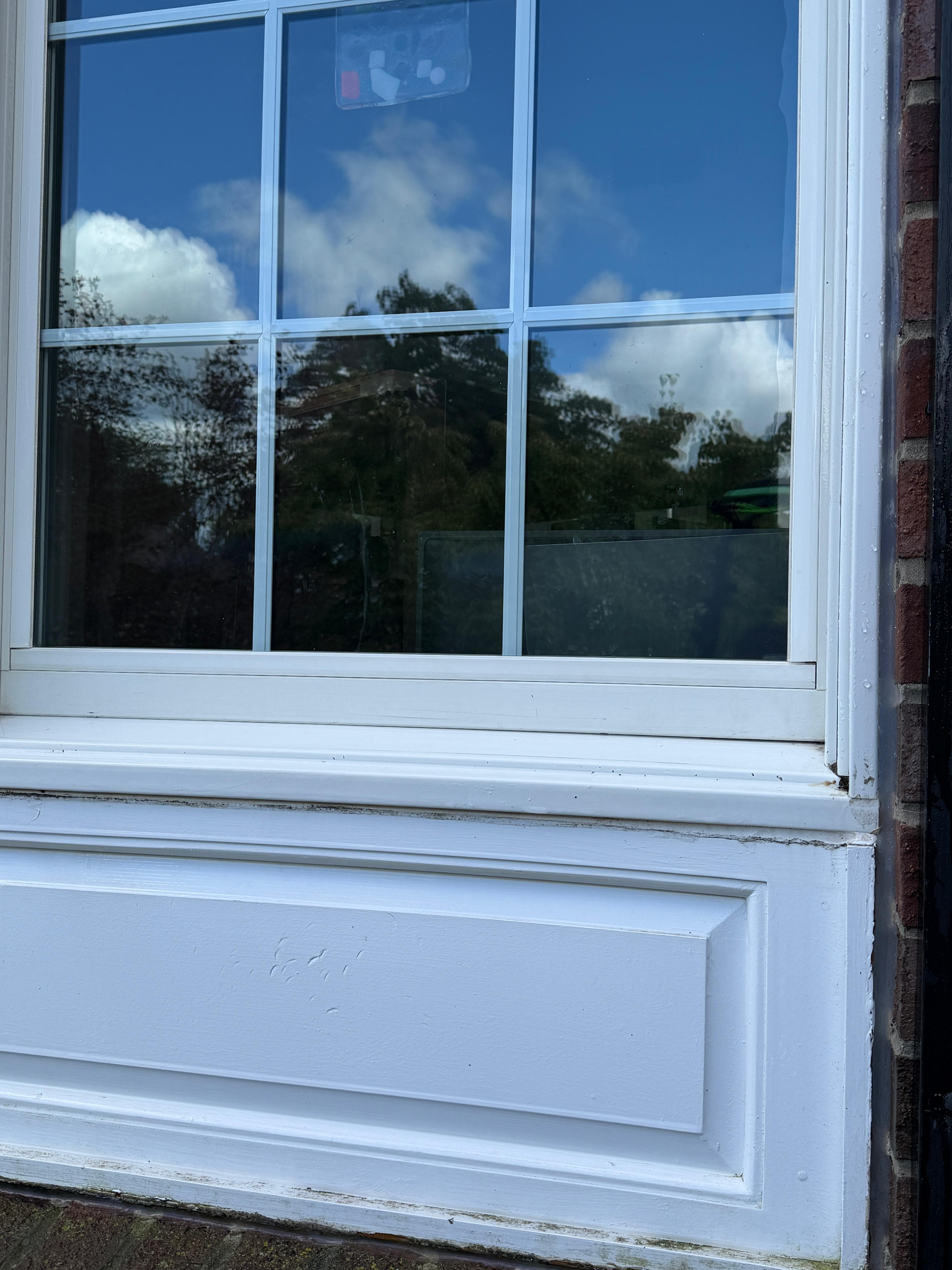 The same sill and brick ledge cleaned back to crisp white after exterior window cleaning